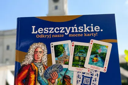 Broszura na tle wieży Ratusza w Lesznie.
