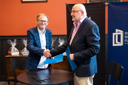 Dyrektor MBP i przedstawiciel stowarzyszenia po podpisaniu umowy o partnerstwie strategicznym.