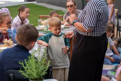 Chłopiec poznaje zapach suszonych ziół podczas warsztatów.