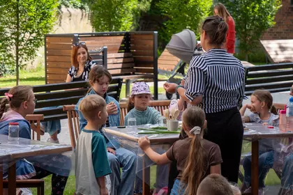 Dzieci poznają właściwości ziół podczas zajęć w bibliotecznym ogrodzie.
