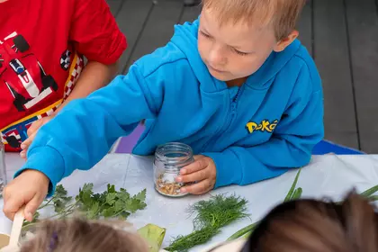 Chłopiec przygotowuje pachnącą sól ziołową do kąpieli.