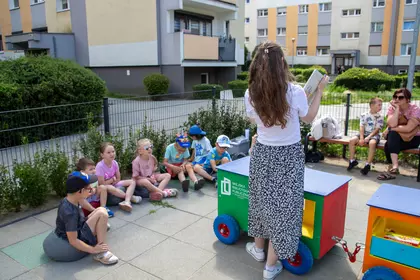Dzieci słuchają głośnego czytania podczas spotkania z Bajkomotywą.