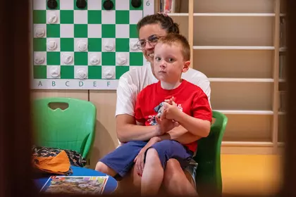 Matka z dzieckiem uczestniczą w wakacyjnych zajęciach w bibliotece.
