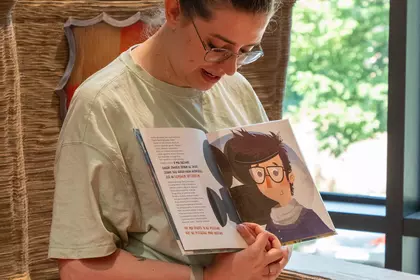 Bibliotekarka czyta dzieciom książkę podczas spotkania o Janie Brzechwie.
