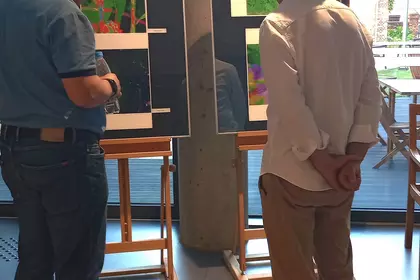 Dwóch mężczyzn oglądających od tyłu prace z cyklu „W stronę zieleni”.
