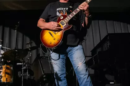 Gitarzysta gra na gitarze elektrycznej podczas koncertu.