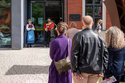 Publiczność słucha muzyków występujących przed biblioteką.