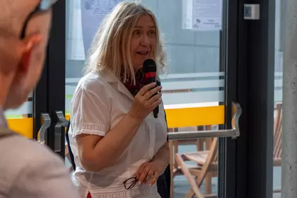 Prowadząca spotkanie przedstawia temat wydarzenia przed publicznością.