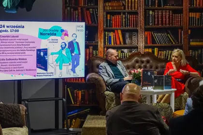 Rozmowa prowadzącego z gośćmi spotkania przed publicznością.