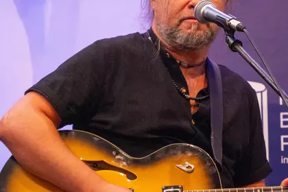 Gitarzysta śpiewający i grający na gitarze elektrycznej.