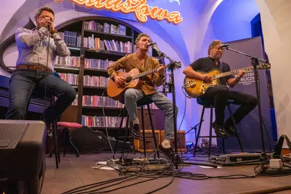 Trzej muzycy podczas występu na scenie Biblioteki Ratuszowej.