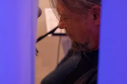 Gitarzysta podczas występu wśród kolorowego oświetlenia.