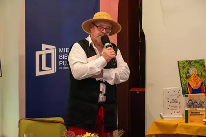 Mężczyzna przemawia do uczestników z mikrofonem.