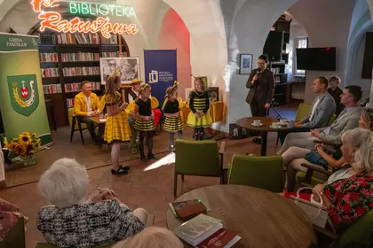 Dzieci w strojach pszczół występują przed publicznością.