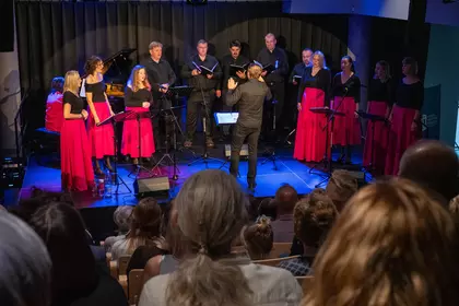 Zespół Wokalny Cantus występuje na scenie pod batutą dyrygenta.