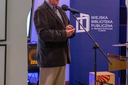 Prelegent przemawia przed mikrofonem.