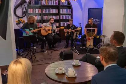 Zespół muzyczny gra koncert na scenie Biblioteki Ratuszowej.