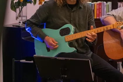 Gitarzysta gra na scenie Biblioteki Ratuszowej.