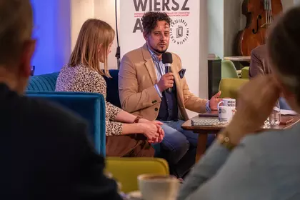 Prelegent opowiada podczas spotkania w Bibliotece Ratuszowej.